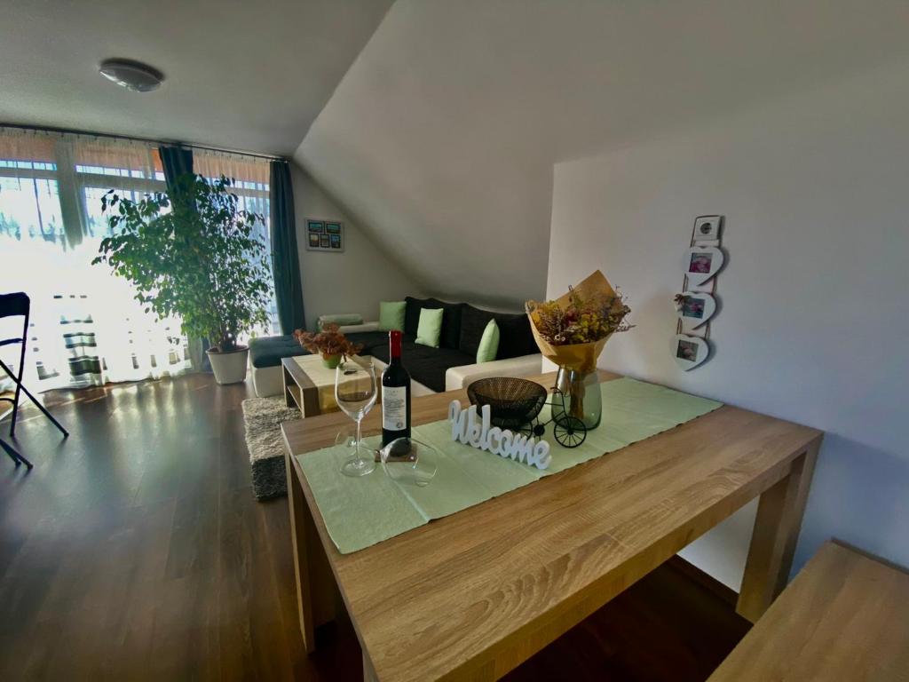 鲍洛通费尼韦什Munkácsy Apartmanok的客厅配有带酒杯的木桌