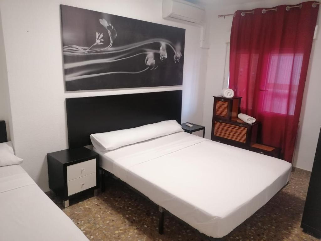 马德里Hello Madrid的一间卧室设有两张床,墙上挂着一幅画