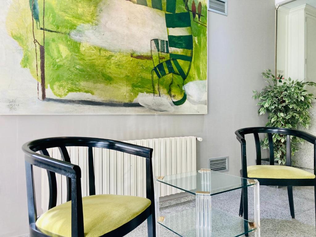 卡斯特利翁-德拉普拉纳扎梅尔酒店的画室里设有两把椅子和一张玻璃桌