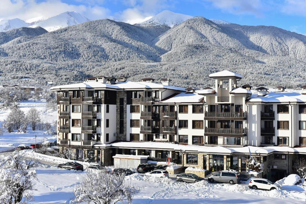 班斯科St George Ski & Holiday - Half Board & All Inclusive的山底下雪中的酒店