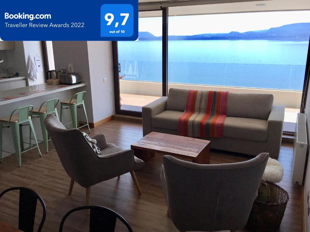 普孔Depto. orilla de lago Villarrica的客厅配有沙发、椅子和桌子