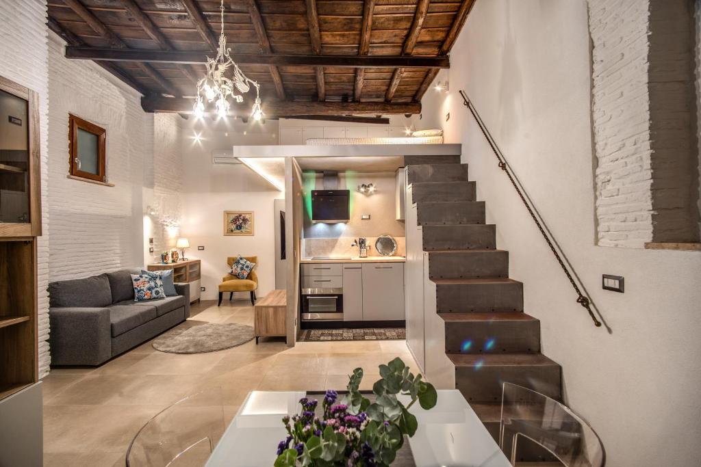 罗马Casa Vantaggio的一间带楼梯和沙发的客厅
