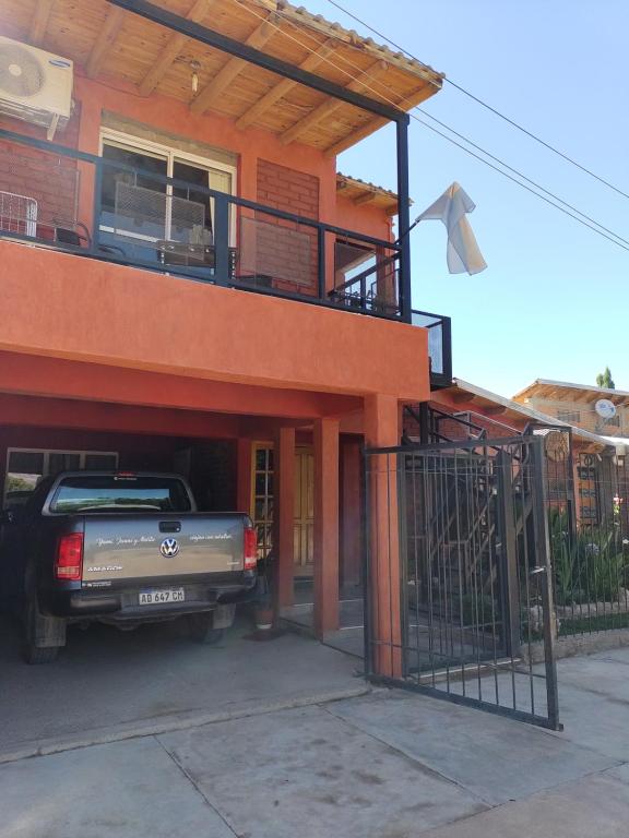 乌斯帕亚塔Departamento Uspallata的停在带阳台的房子外的卡车