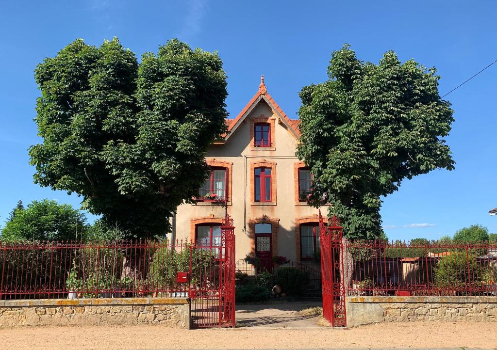 LezouxMAS TERRE Chambres d'Hôtes的一座带红门和两棵树的老房子