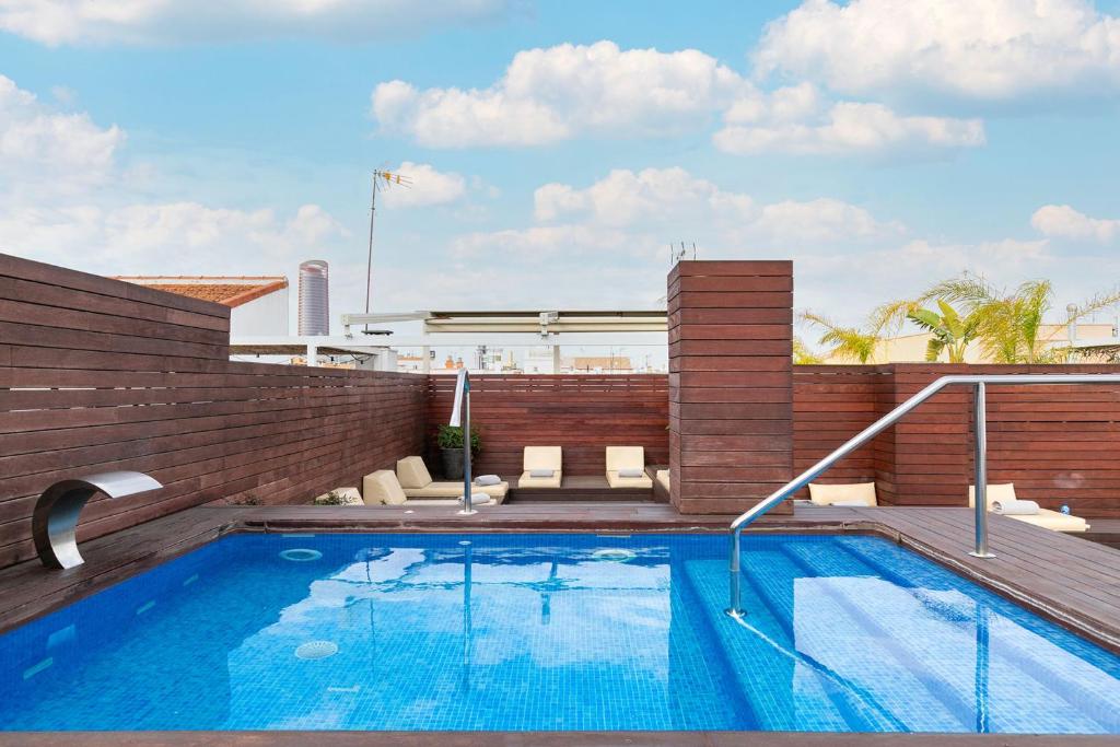 塞维利亚Holiday Rentals Tempa Museo的建筑物屋顶上的游泳池