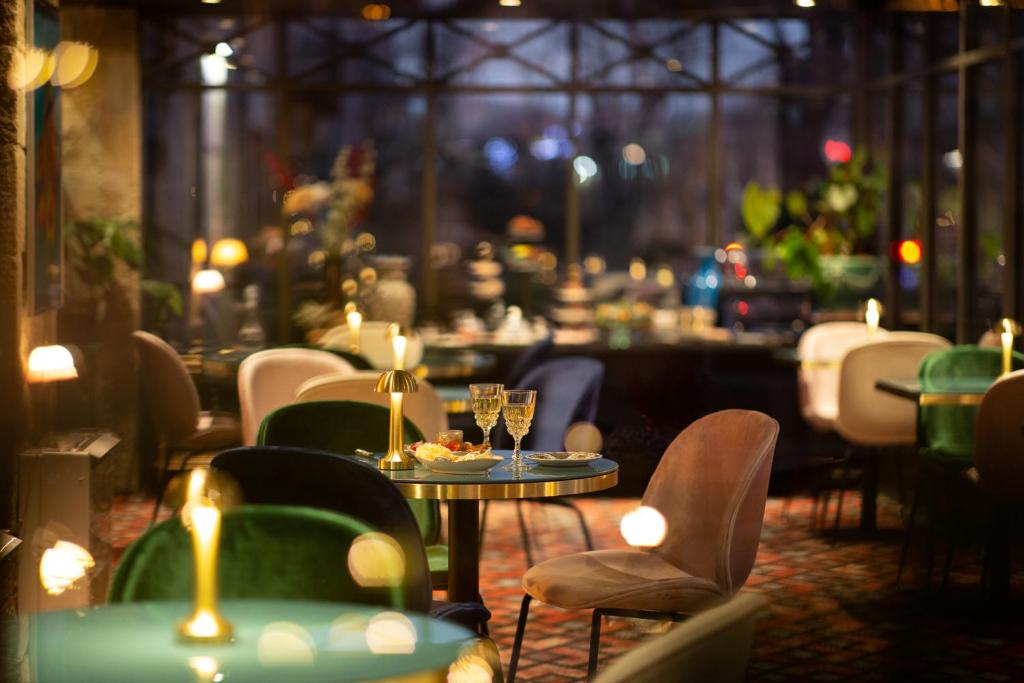 布里夫拉盖亚尔德Hôtel De Charme Le Chêne Vert的餐厅设有桌椅和酒杯