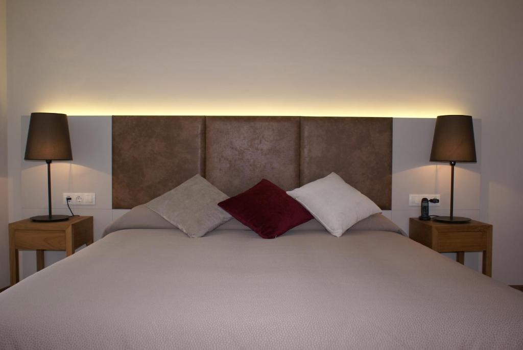 菲格拉斯K公寓酒店的一间卧室配有一张大床和两盏灯