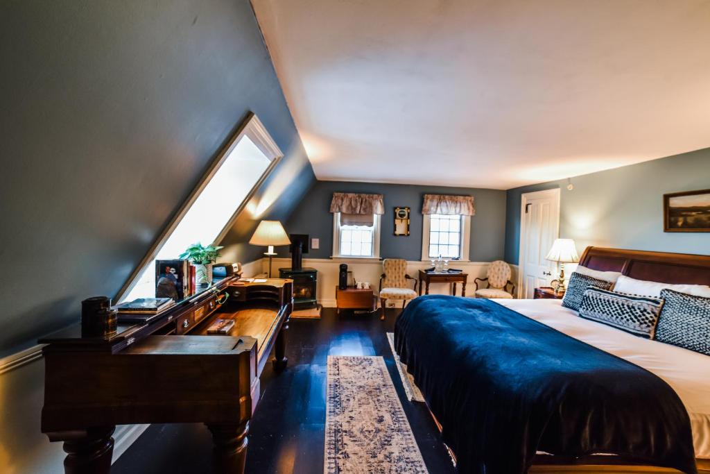 伯利恒阿代尔乡村餐厅旅馆的一间卧室配有一张大床和一架钢琴