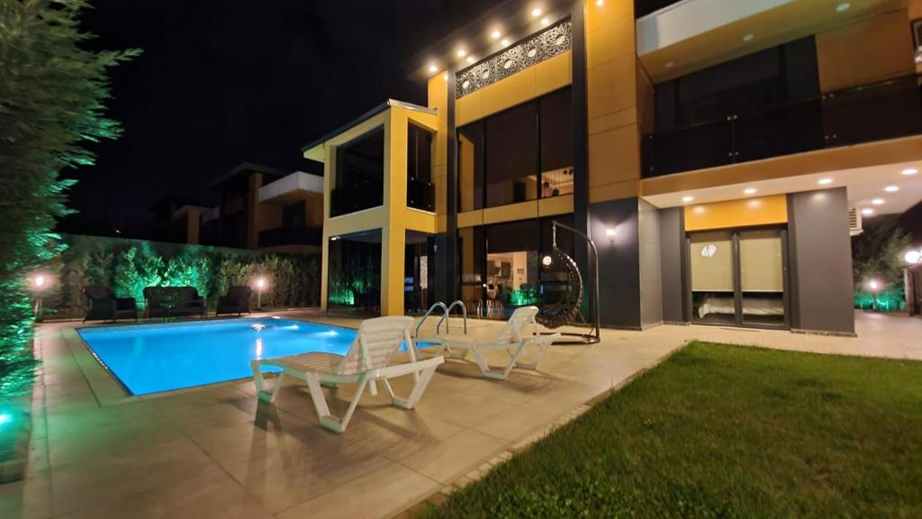萨潘贾Villa Aysha 2的一座晚上设有游泳池的房子