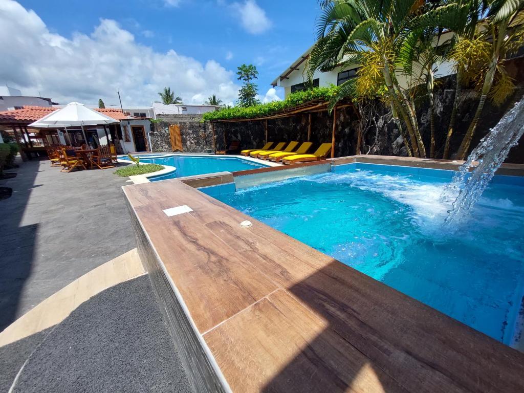 阿约拉港Hotel Las Ninfas的一个带木凳和喷泉的游泳池
