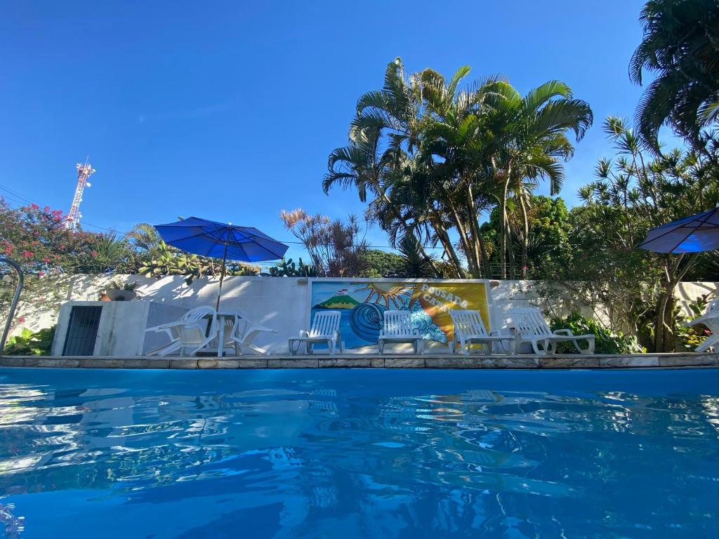 萨夸雷马卡塔温托旅馆 的一个带椅子和遮阳伞的游泳池