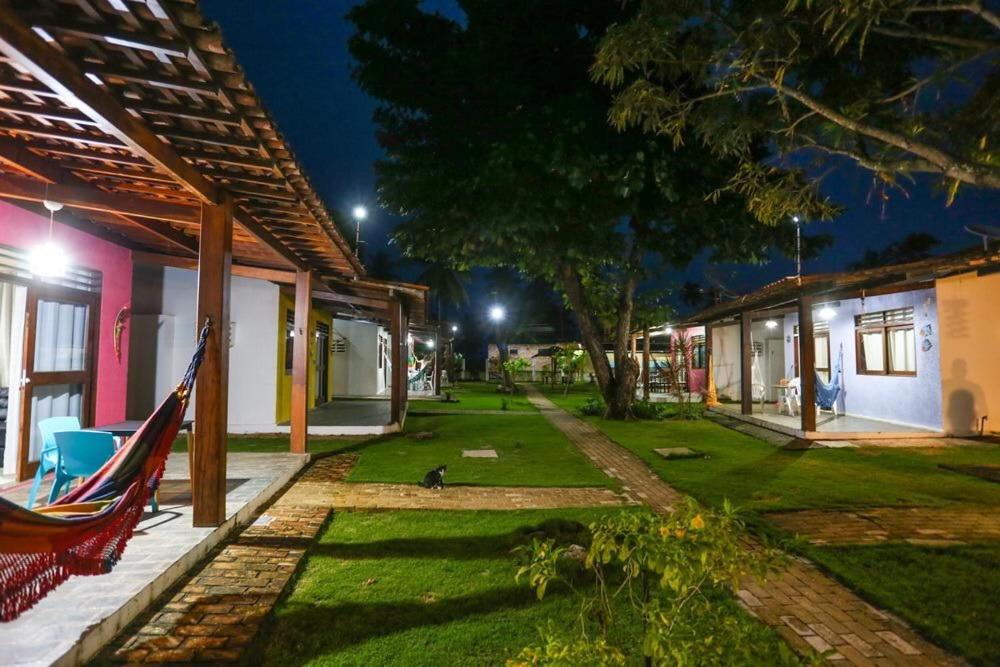 马拉戈日Chalés Praias Brasileiras的夜间房子的院子内的吊床
