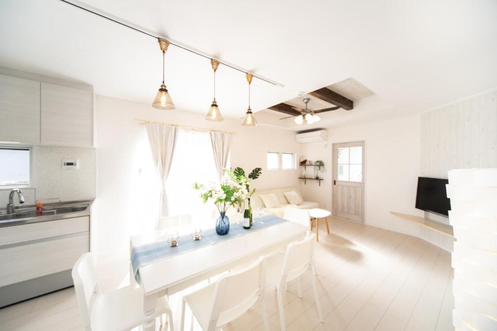 淡路Shizukinosato TSUKI Terrace 531的白色的厨房以及带桌椅的客厅。