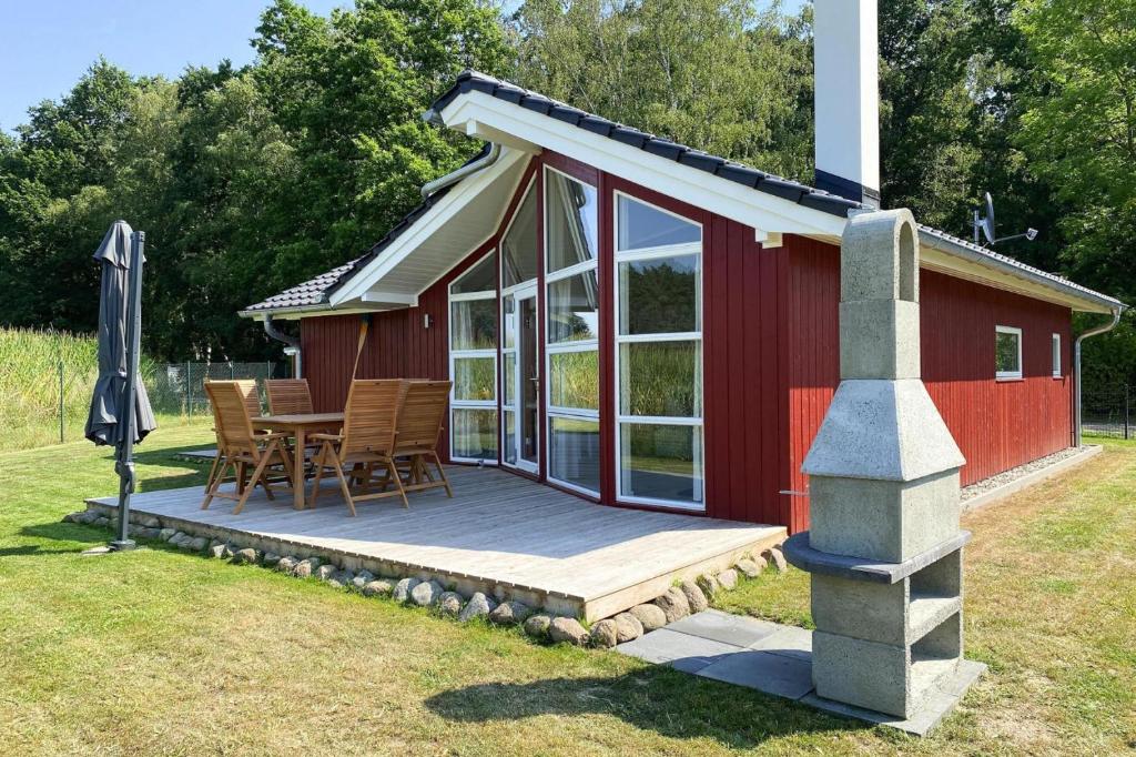 DümmerFerienhaus Larsson mit Sauna am Dümmer See, Dümmer的红色小屋设有甲板和桌椅