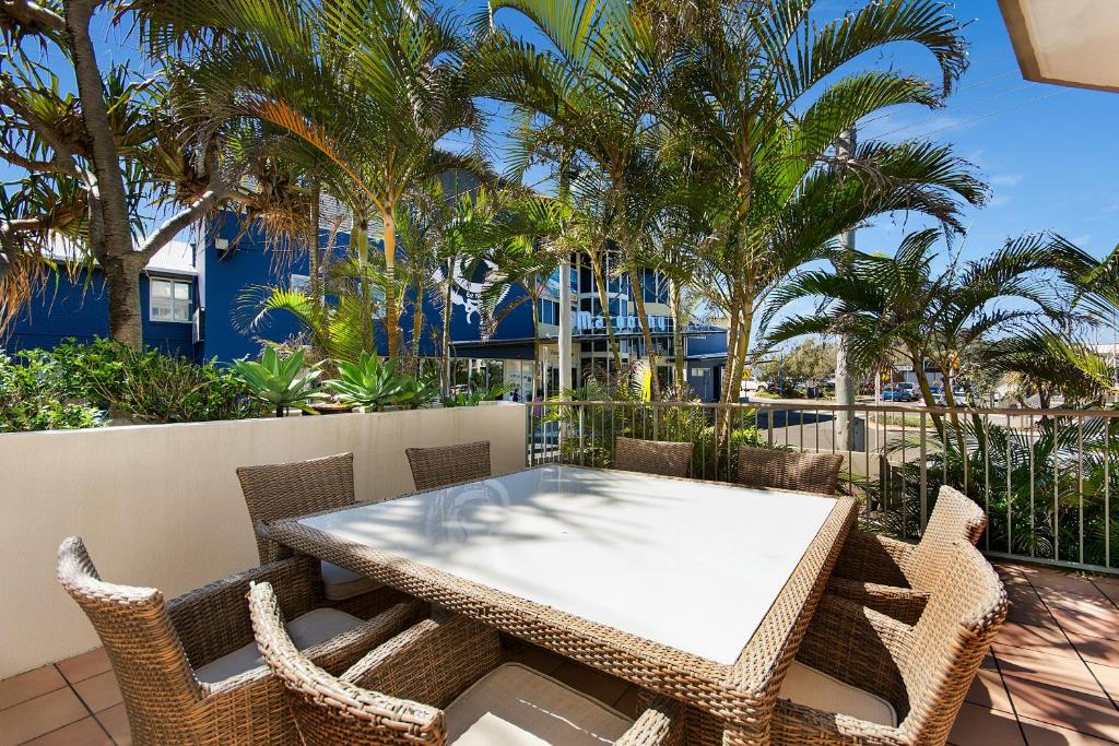 玛志洛海滩上冲浪者酒店的棕榈树阳台的桌椅