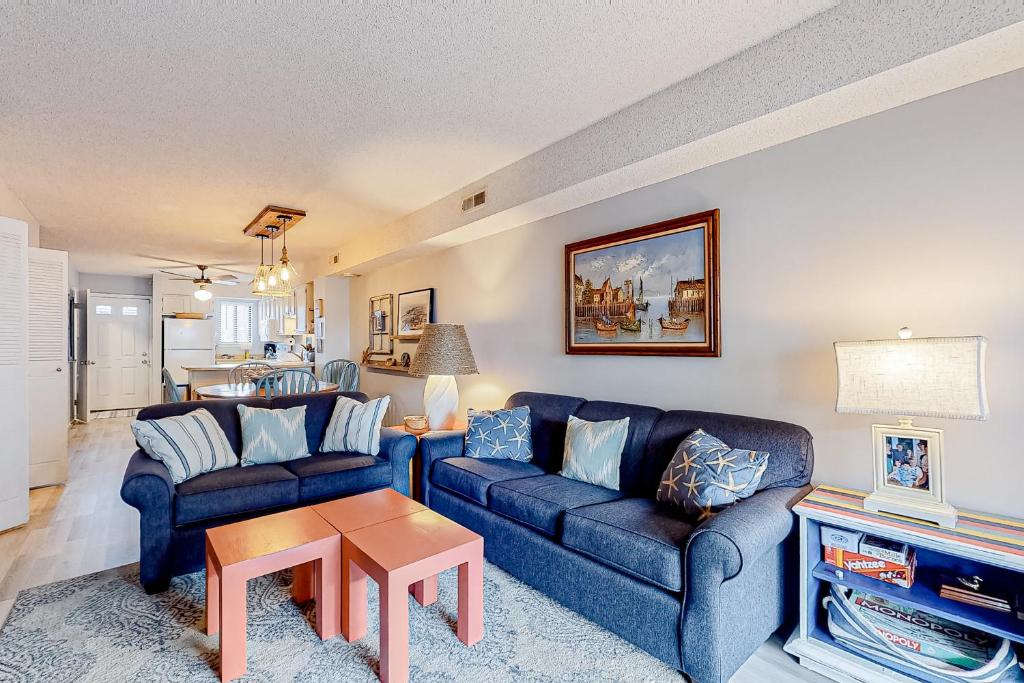 大洋城Bermuda Bay 9的客厅配有2张蓝色的沙发和1张桌子