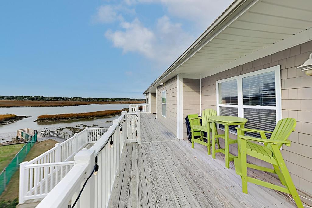 海洋岛海滩Top floor Oasis的房屋内一个带两把椅子和一张桌子的甲板