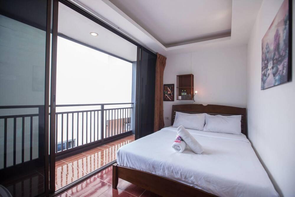 卡马拉海滩Kamala bay inn的一间卧室设有一张床和一个大窗户