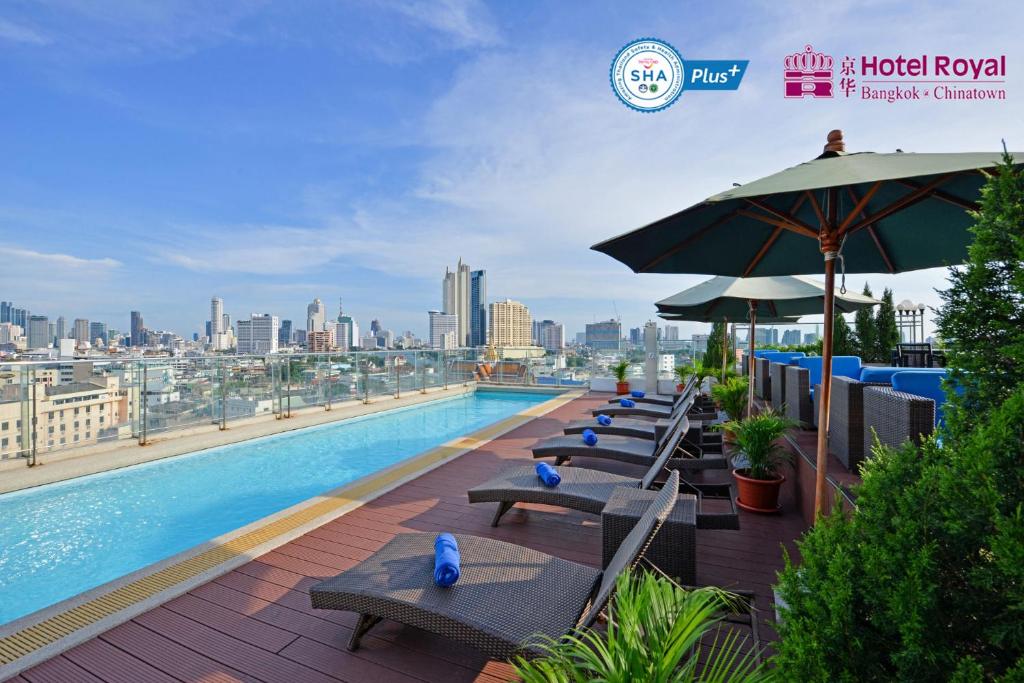 曼谷曼谷唐人街皇家酒店的一座带椅子和遮阳伞的游泳池