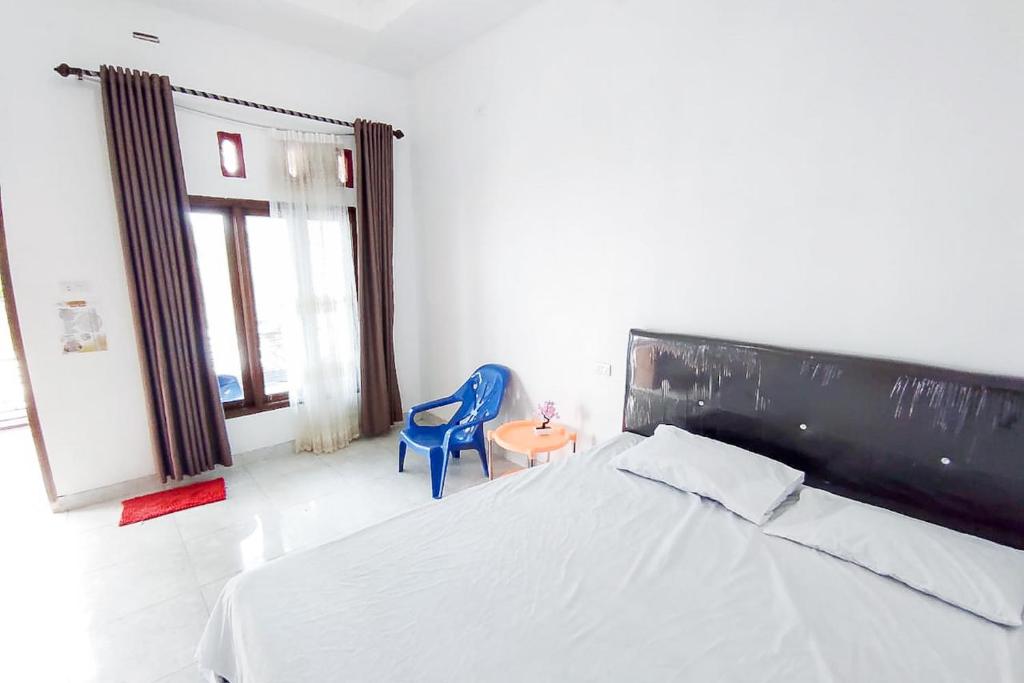 比哈尔Sapu Nyapah Losmen Syariah Tanjung Setia的一间卧室配有一张床和一张蓝色椅子