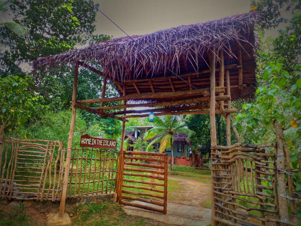 坦加拉Home in the Island的小屋前面有栅栏和标志