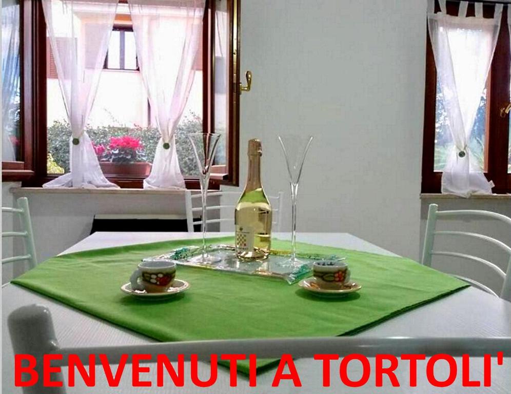 托尔托利Appartamento La Rocca的一张桌子上放着一瓶葡萄酒,放上两杯