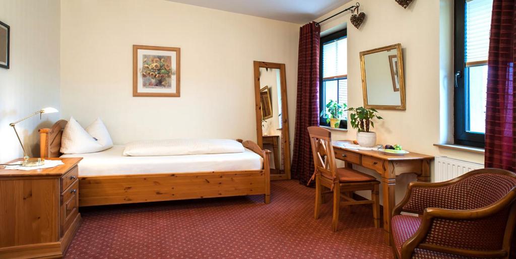 RödentalGasthof Sauerteig的酒店客房配有一张床、一张书桌和一张书桌。