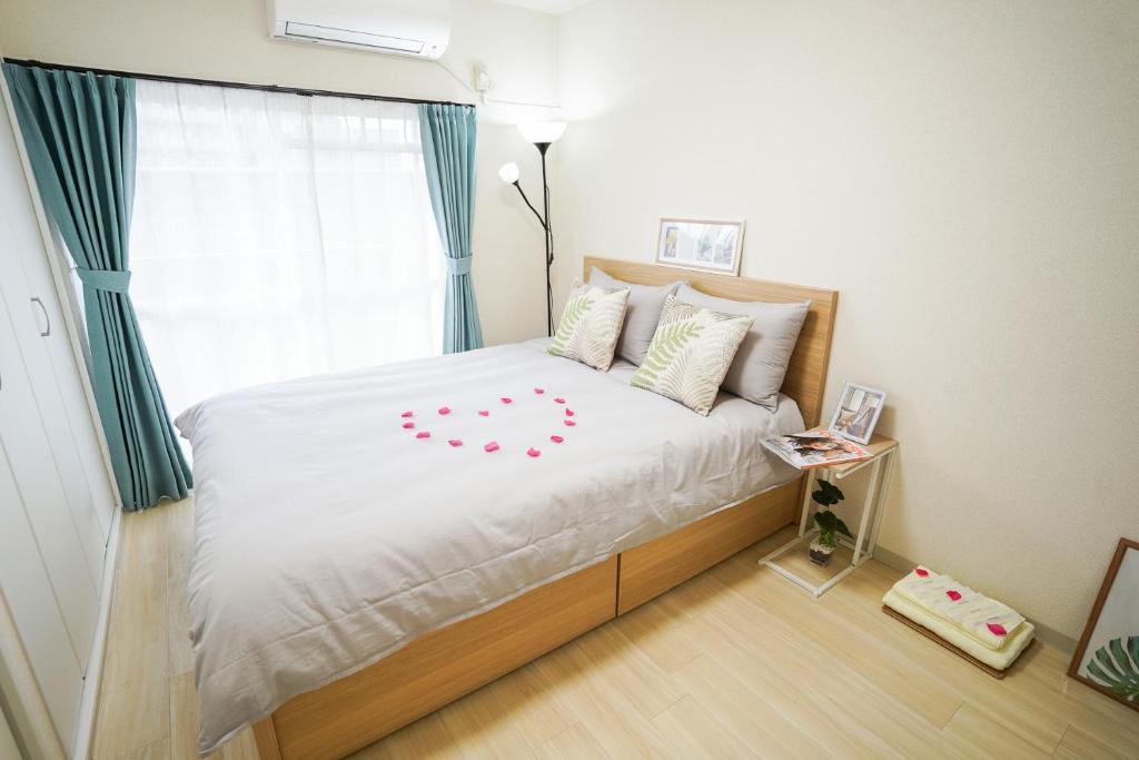 名古屋stay's サンジョイフル 303号 名古屋 民泊 駅近的一间卧室配有一张带白色床单的床和一扇窗户。