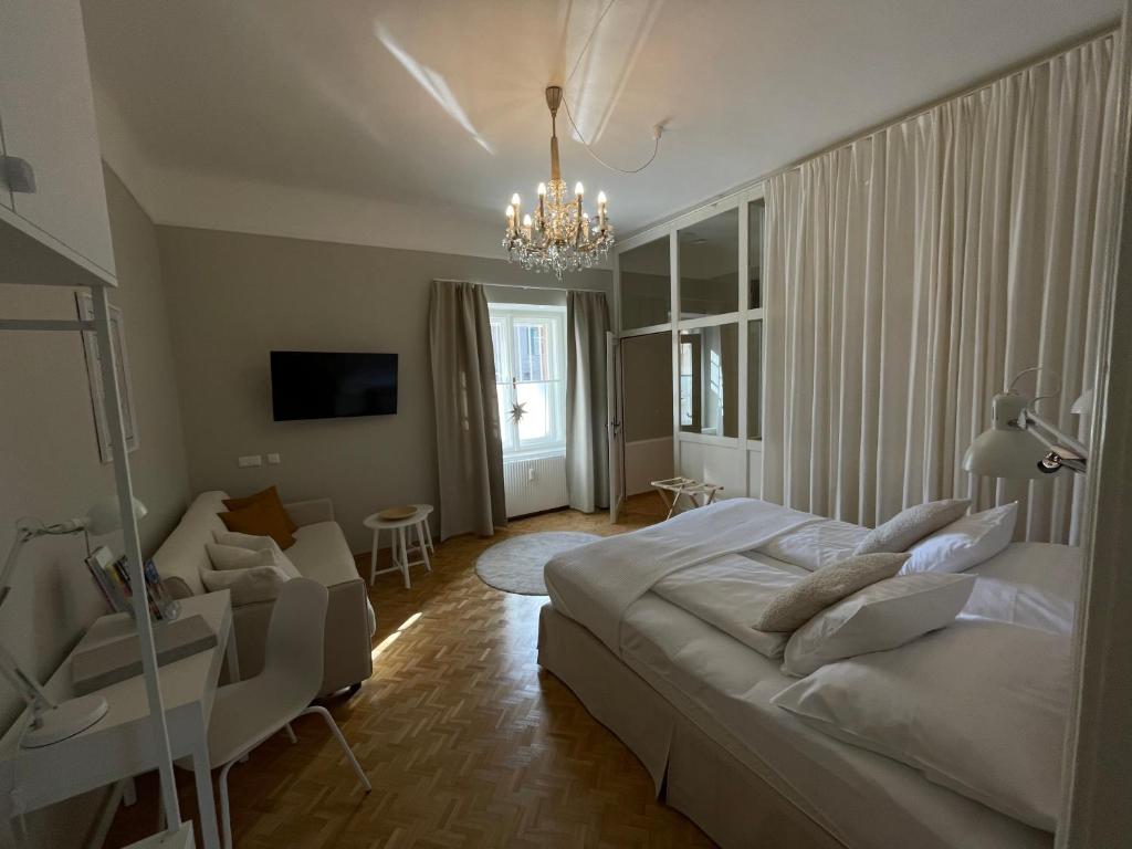 格拉茨White Flat by GrazRentals with cool location & free parking的一间卧室配有一张大床和一个吊灯。