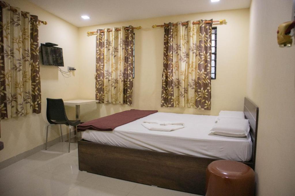 胡布利Shri Vasant Lodge的客房设有床、书桌和窗帘