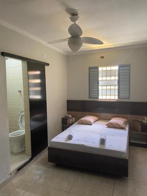 毛阿Hotel Ouro de Mauá的一间卧室配有一张床,浴室设有卫生间