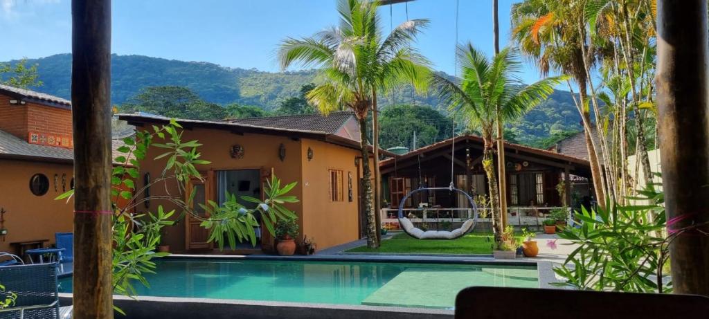 朱奎Hostel Txai Juquehy Suítes的一个带游泳池和棕榈树的度假村