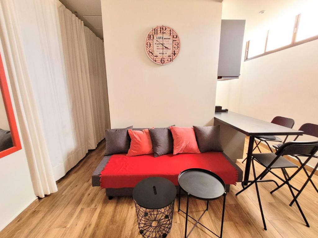 圣地亚哥港La Arena studio的客厅配有红色的沙发和桌子