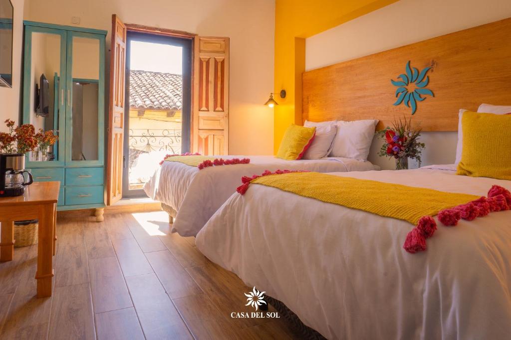 圣克里斯托瓦尔-德拉斯卡萨斯Hotel Casa del Sol的酒店客房设有两张床和窗户。