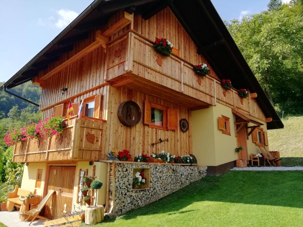 卢斯Počitniška hiška Kašta的花朵上的木头房子