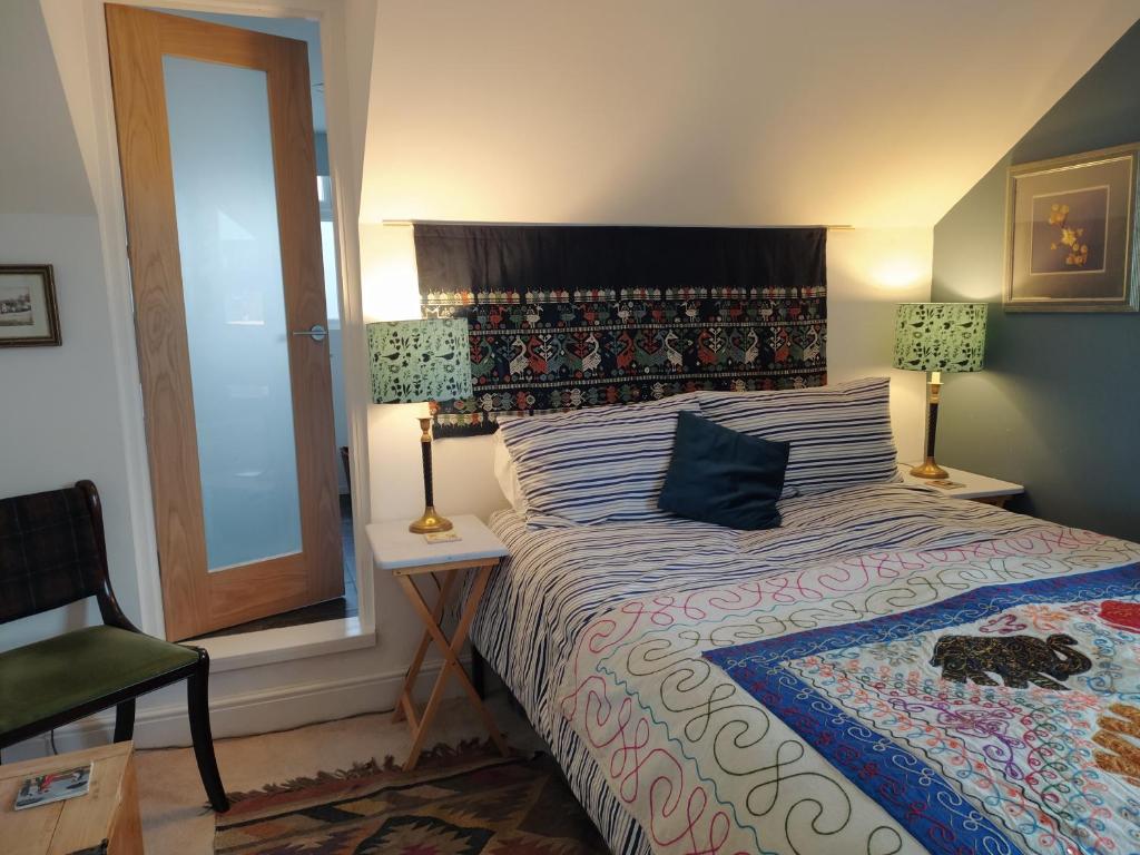 利明顿温泉Offa Home的卧室配有床、椅子和窗户。