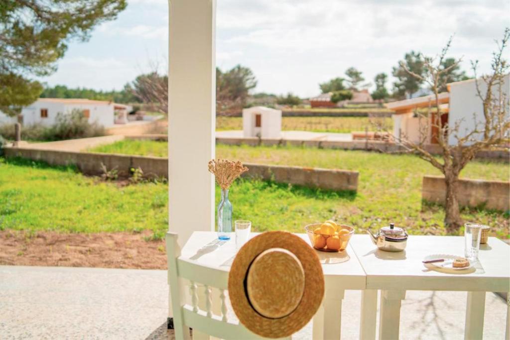 圣弗朗西斯科哈维尔Casa rural Can Pep de Sa Barda - Entre viñedos - Formentera Natural的坐在门廊上的带草帽的桌子