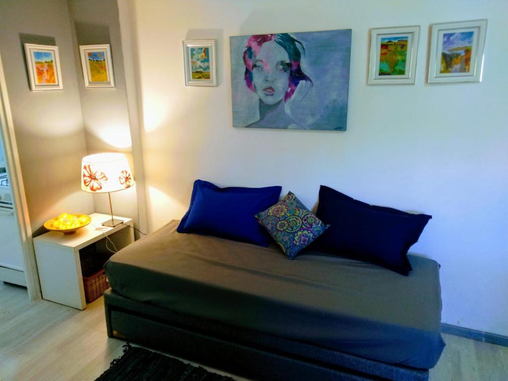 科尔多瓦Calicanto的卧室配有一张床,墙上挂有绘画作品