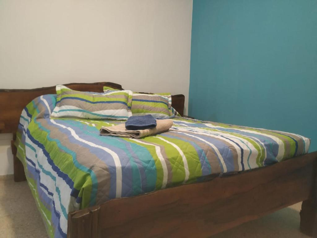 图努扬MI CASA APARTS的一张带五颜六色的被子和两个枕头的床