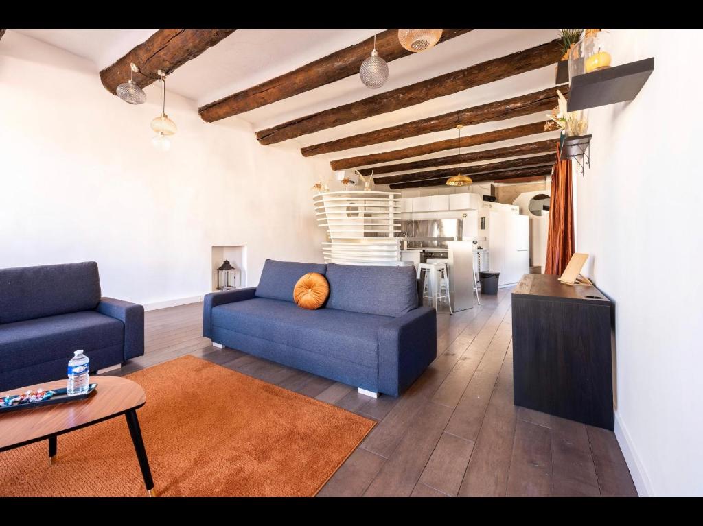 马赛LOFT VIEUX PORT的一间带2张蓝色沙发的客厅和一间厨房