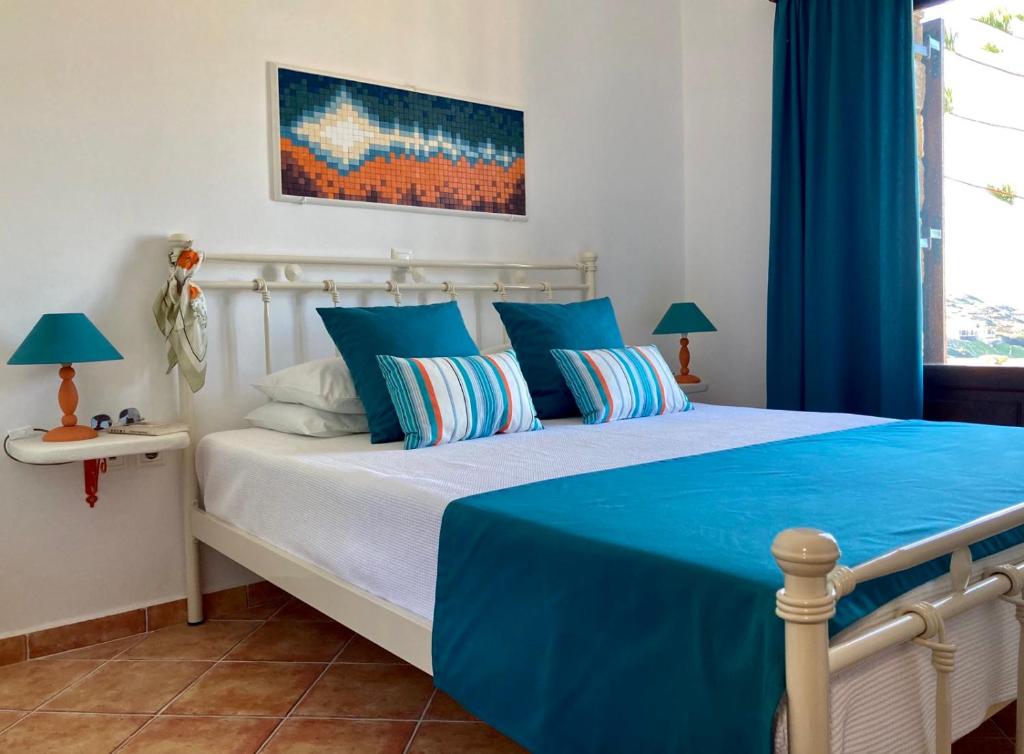 金尼昂SYROU LOTOS Studios & Apartments的一间卧室配有一张大床,提供蓝色的床单和枕头