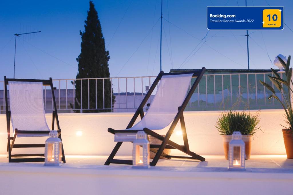 法萨诺Dimora D'Erchia Apulian Holidays的两把椅子坐在带灯的阳台的顶部