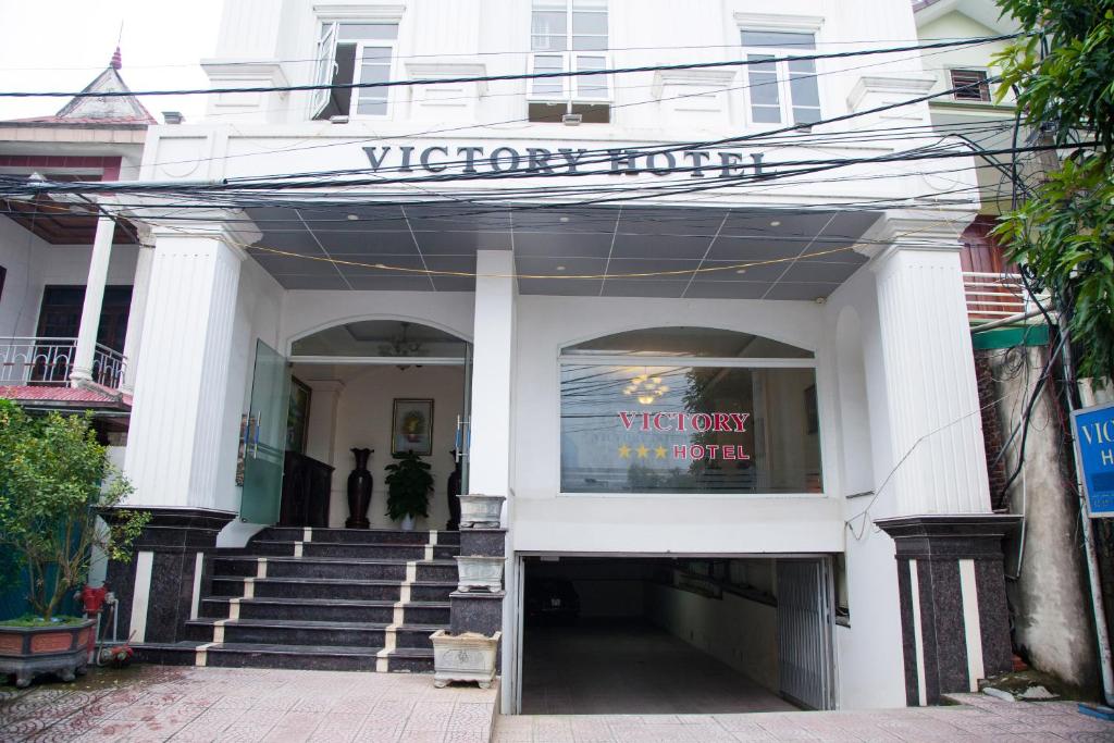 荣市Victory Hotel, số 7, Vương Thúc Mậu, Tp Vinh的一座白色的建筑,上面有读取胜利宾馆的标志