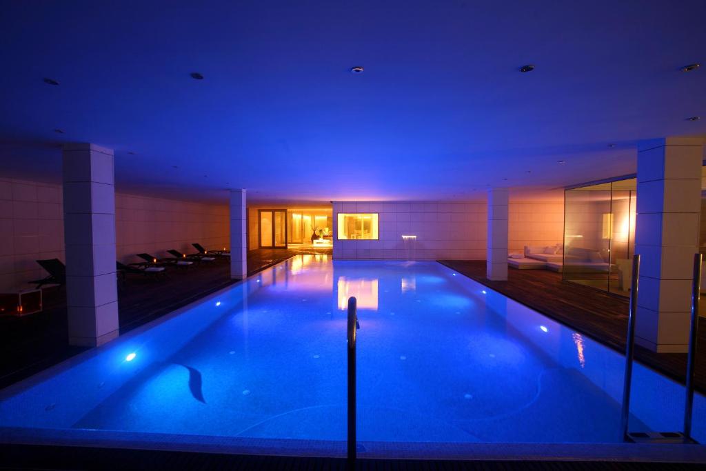 莱里达普拉茨庄园高尔夫水疗酒店的蓝色灯光建筑中的一个大型游泳池