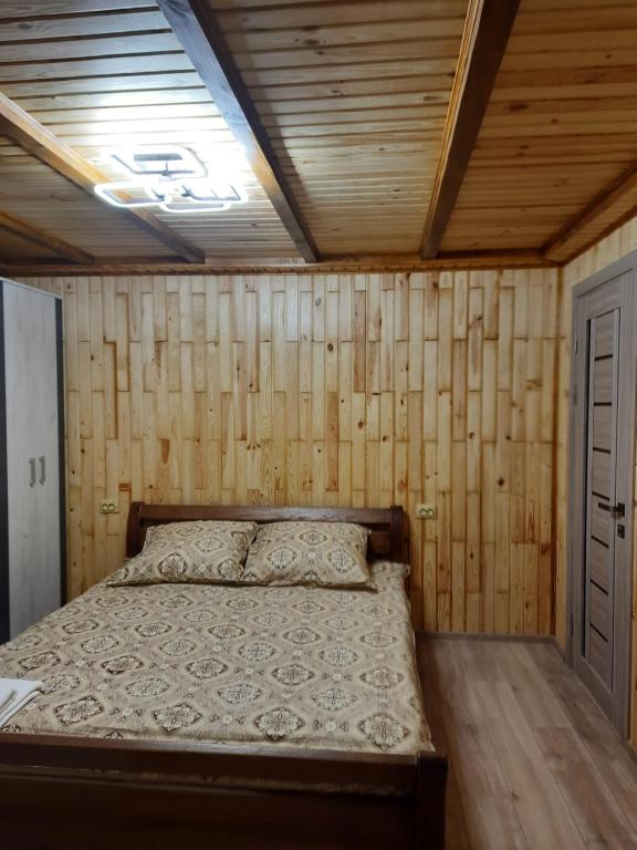 亚列姆切Дух лісу的木墙和天花板的客房内的一张床位