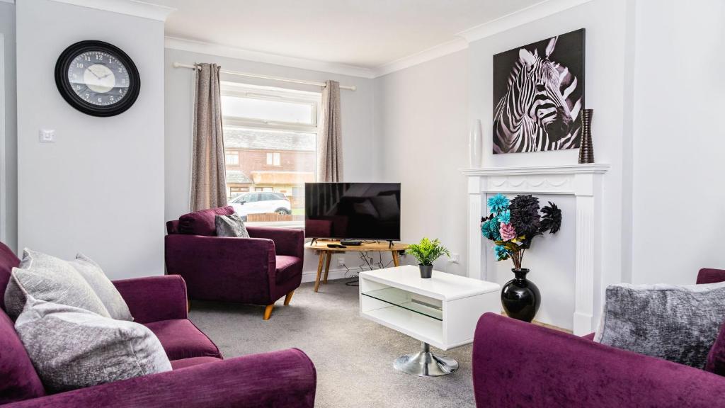 巴罗弗内斯Mill Charm的客厅配有紫色椅子和电视