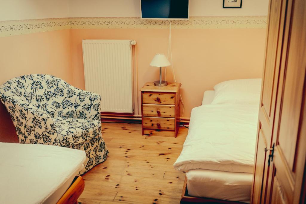 普特布斯Inselgaestehaus-Erna的一间卧室配有一张床、一把椅子和一个梳妆台