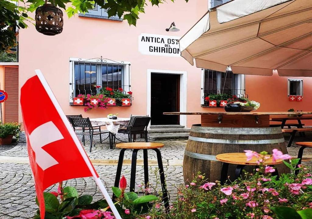 PalagnedraAntica Osteria Ghiridone的一间带桌椅和国旗的餐厅