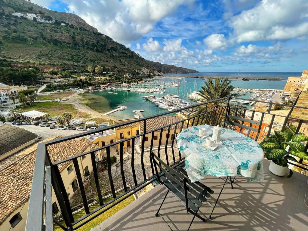 卡斯泰拉马莱Suite Altamarea "Sea View Studios"的阳台配有桌子,享有海港景色
