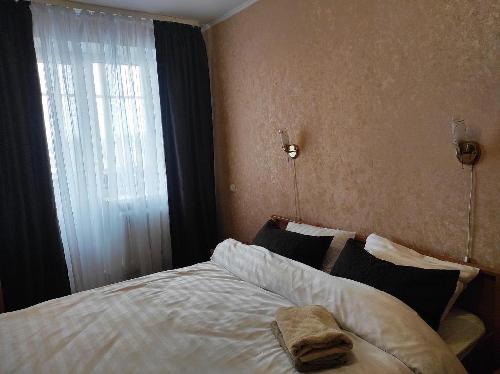 罗夫诺Comfortable apartments in centre with 3 bedrooms的一间卧室设有一张大床和窗户